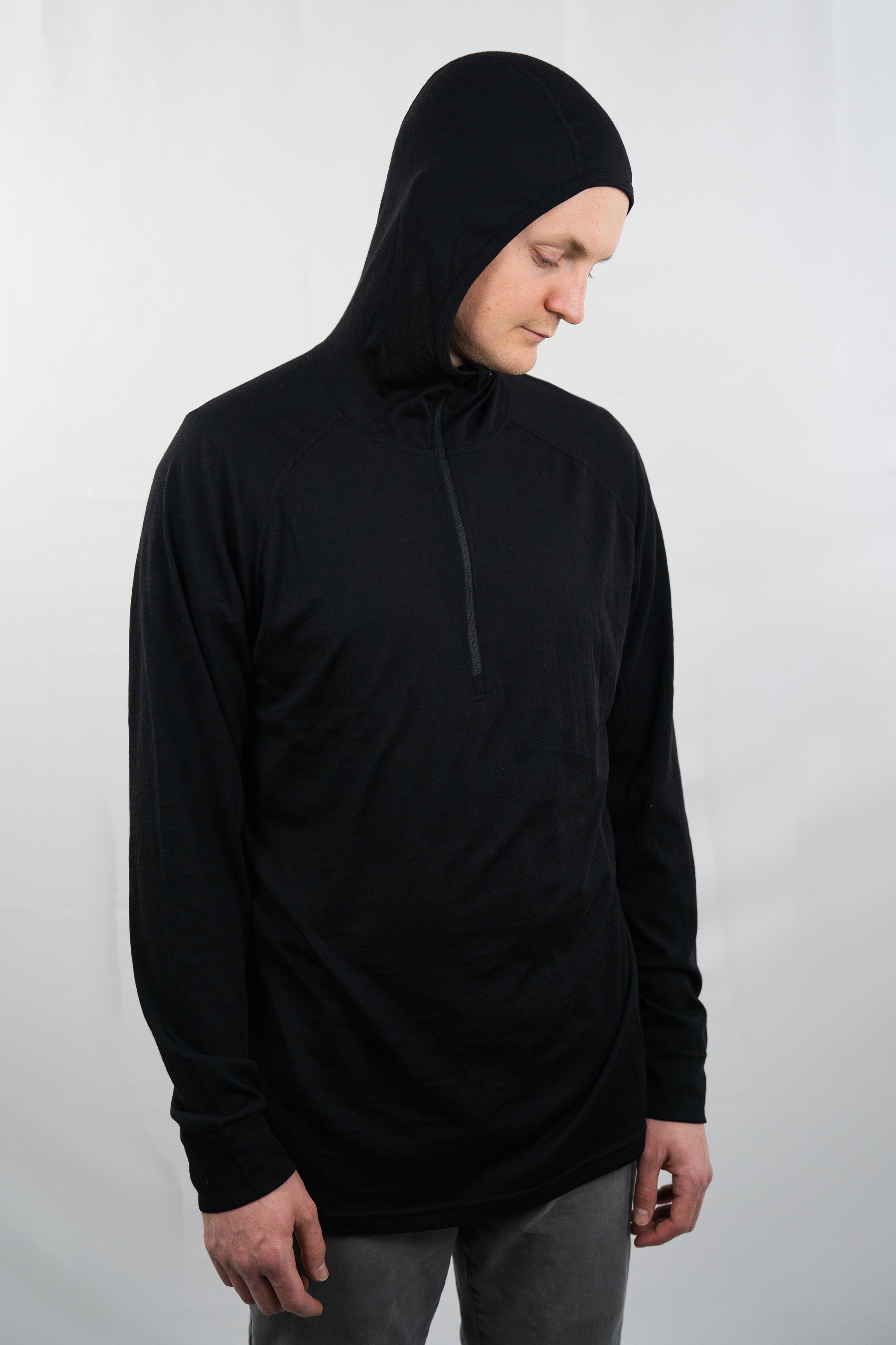 Person wearing black wool base layer hoodie with hood on from Squak Mountain Co.