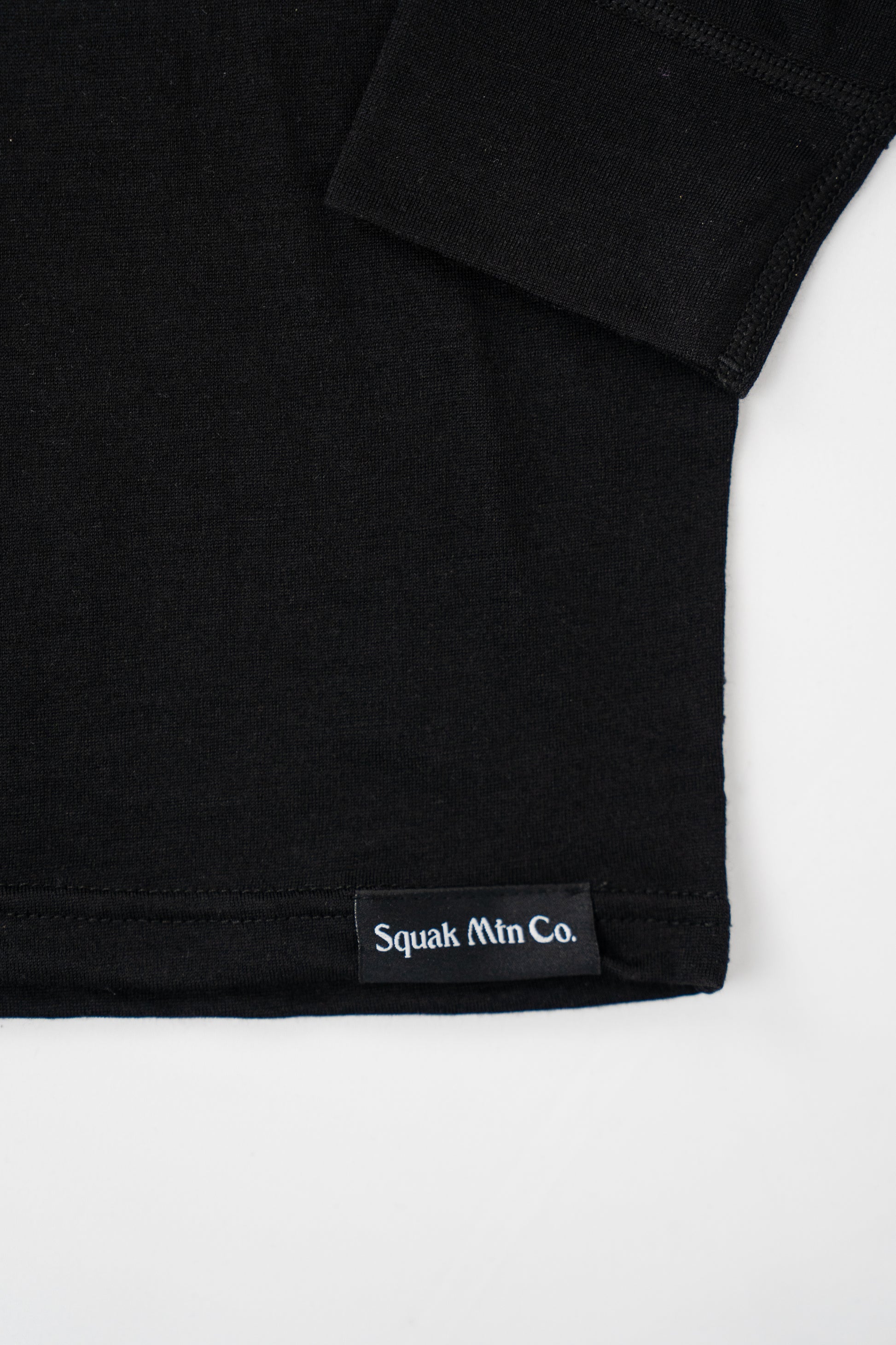 Logo on womens black wool base layer hoodie from Squak Mountain Co.