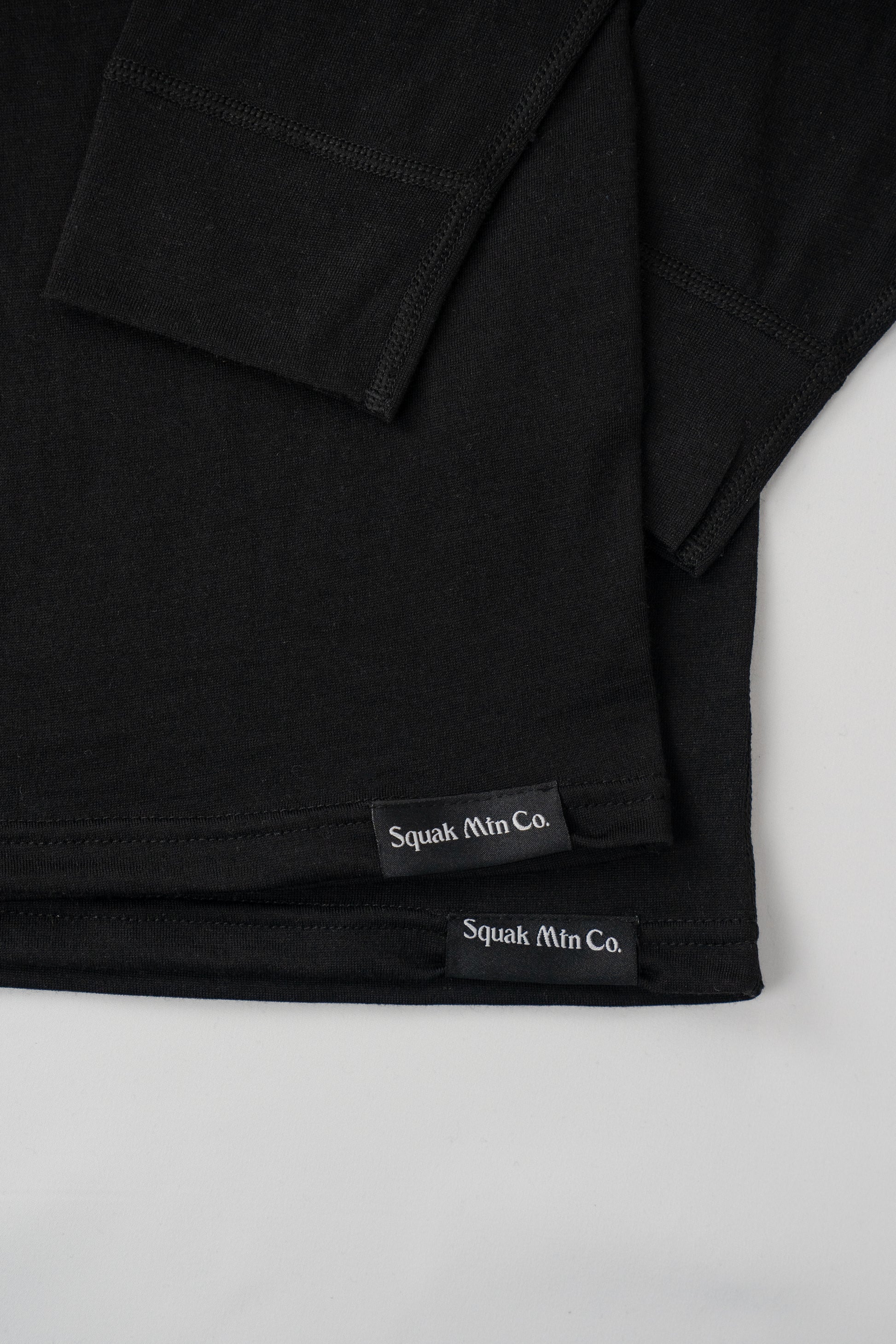Logo on 2 stacked womens black wool base layer hoodie from Squak Mountain Co.