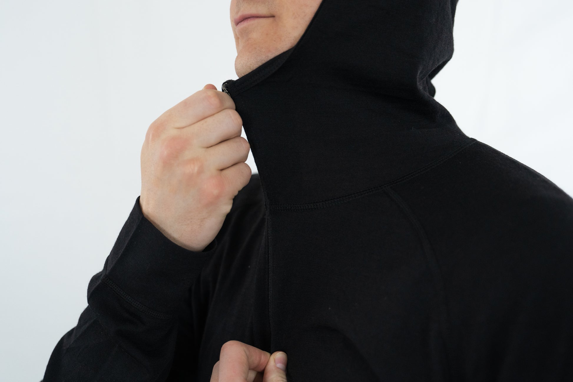 Top half of person wearing black wool base layer hoodie from Squak Mountain Co.